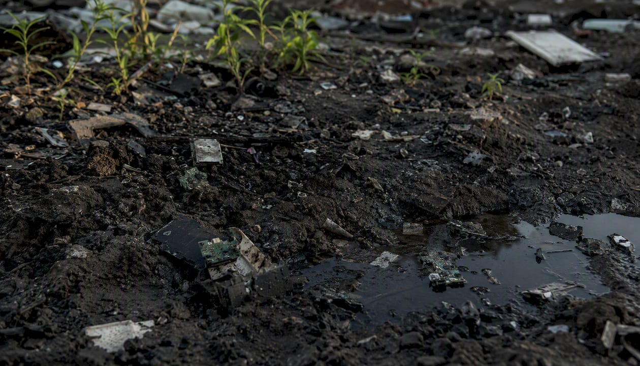 Contaminated soil adjacent to e-waste scrap