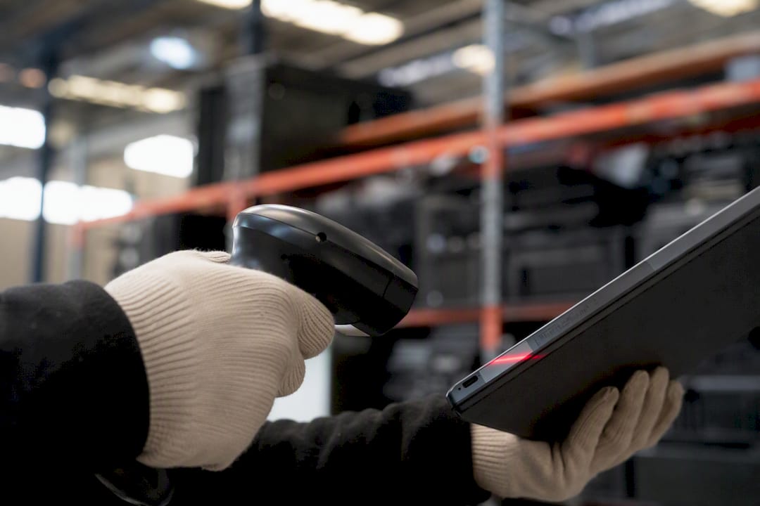 Hands scanning barcode on e-waste device