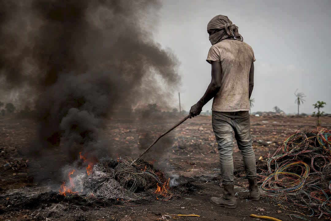 Burning cables releasing smoke in informal e-waste recycling