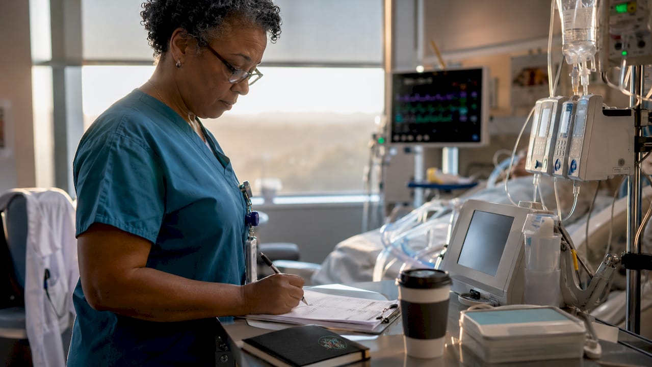 ICU nurse calculating medication doses at workstation