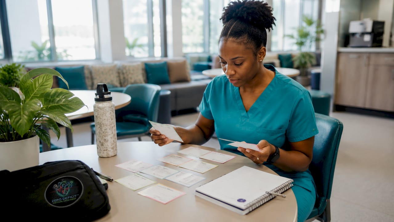 Nurse studying nursing flashcards at ICU station