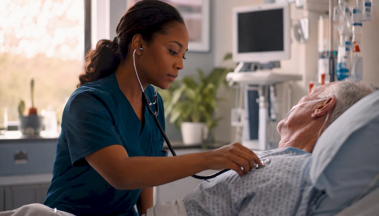 ICU nurse performing focused patient assessment