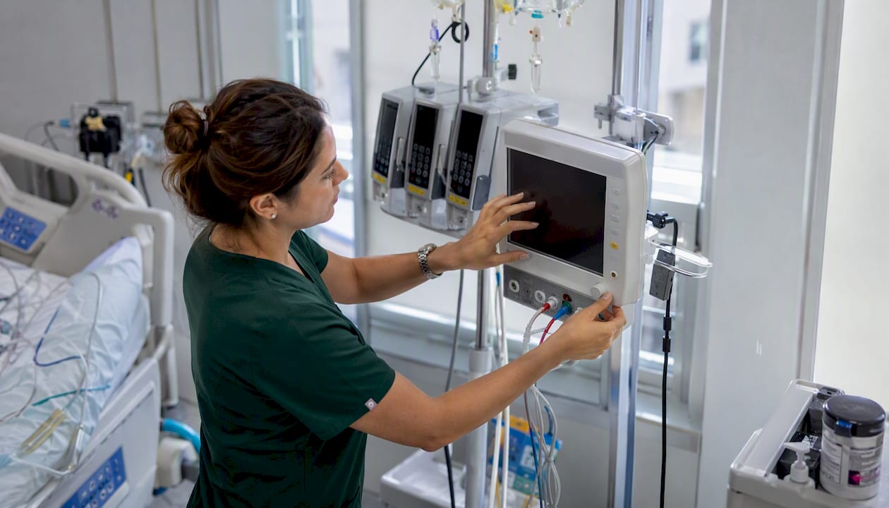 Nurse adjusting hemodynamic monitor in ICU