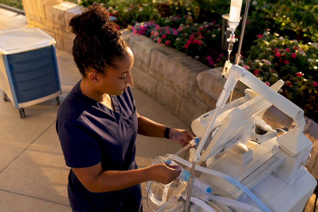ICU nurse adjusting ventilator controls