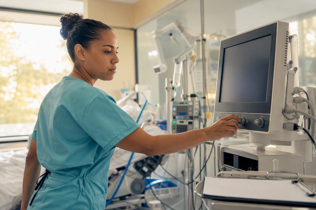 Nurse adjusting hemodynamic monitor in ICU