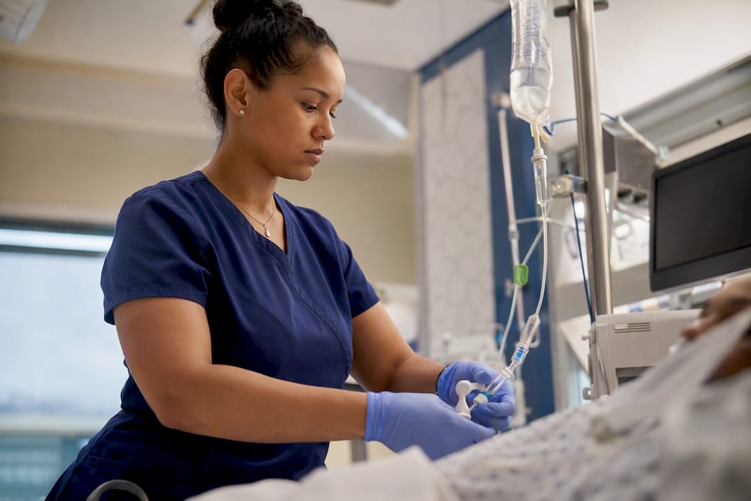 Nurse administering IV analgesia in ICU