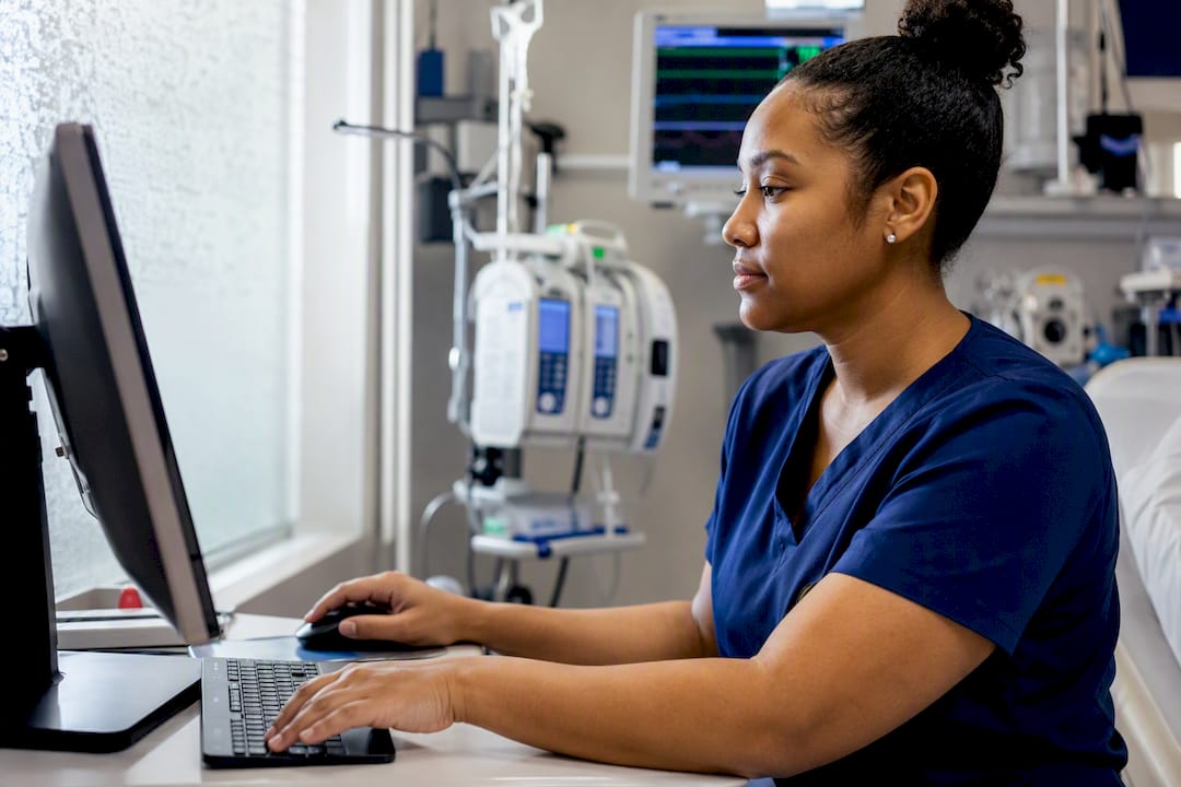 ICU nurse analyzing score report at dark screen