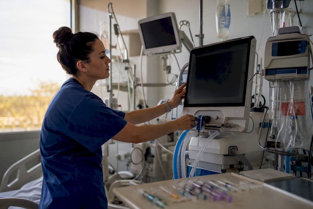 Nurse adjusting ventilator and hemodynamic monitoring