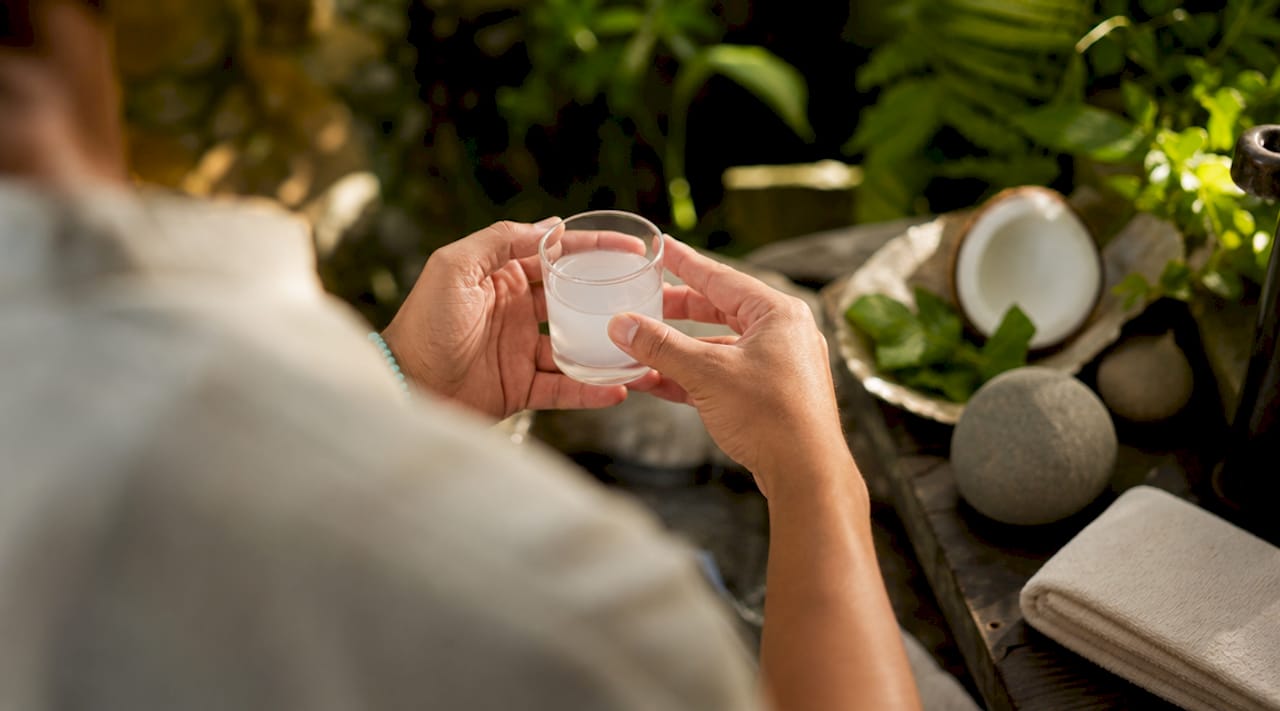 Hands holding mouth rinse cup in bathroom