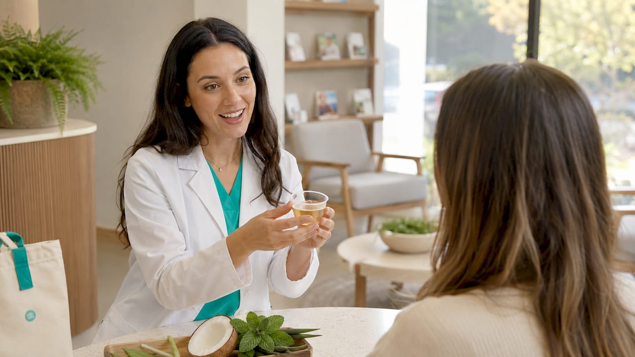 Dental hygienist holding tea tree oil mouth rinse cup