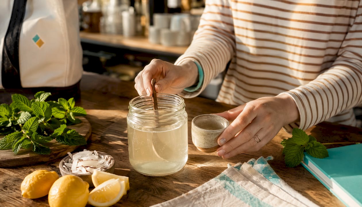 Hands preparing natural fluoride-free mouthwash with botanicals