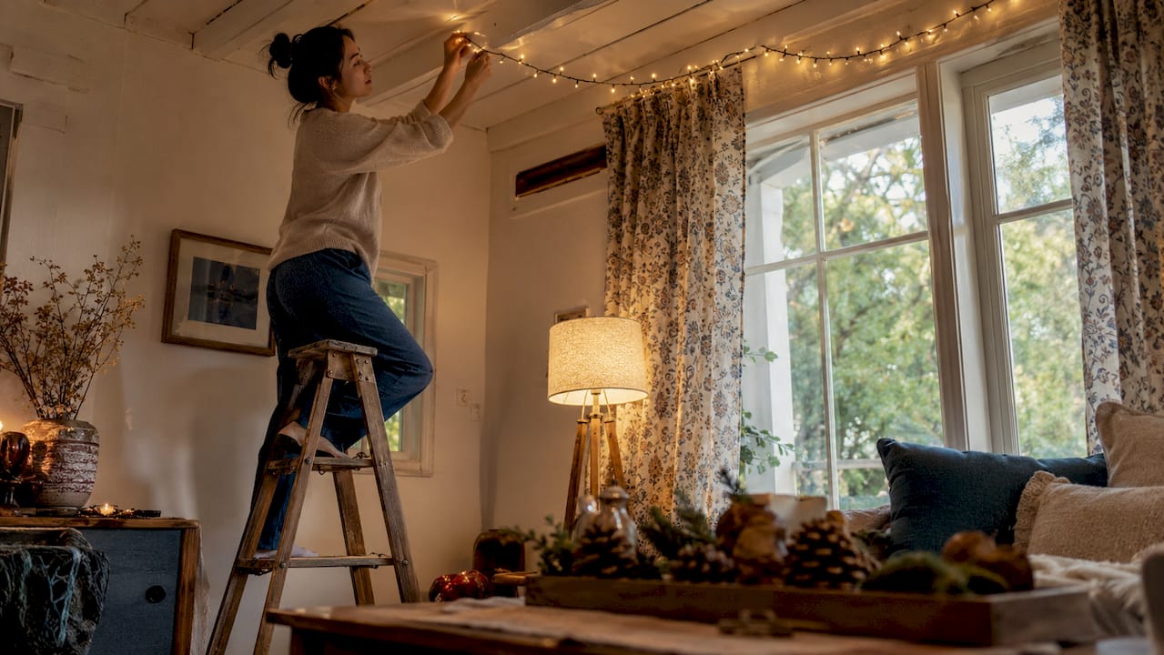 Woman arranging indoor celebration string lights