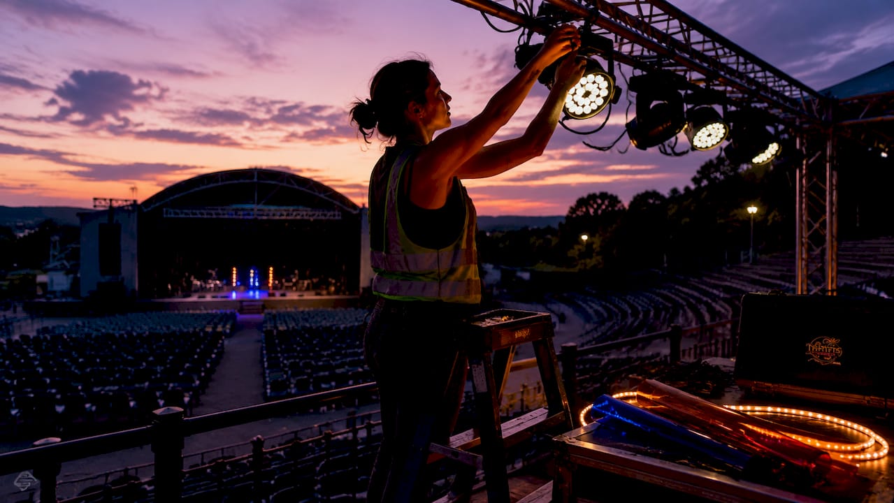Technician adjusting stage lighting fixture