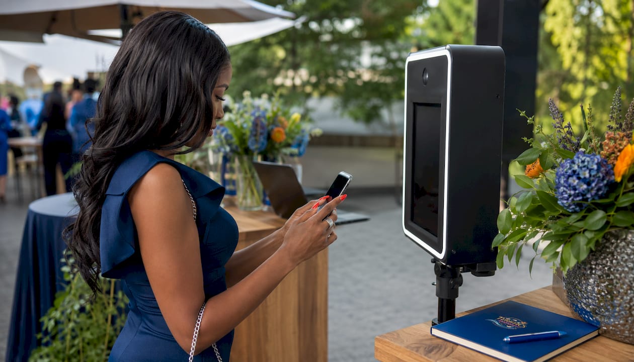 Woman scanning QR at digital social photobooth station