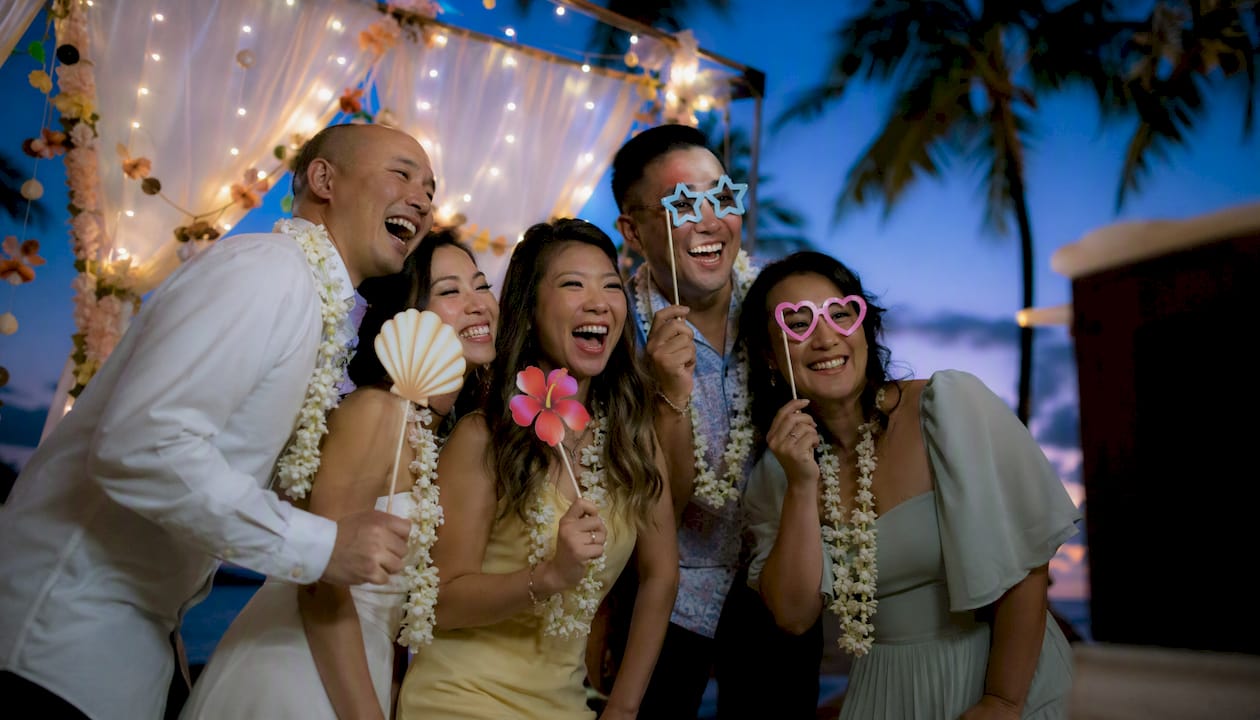 Guests enjoying wedding photo booth with props