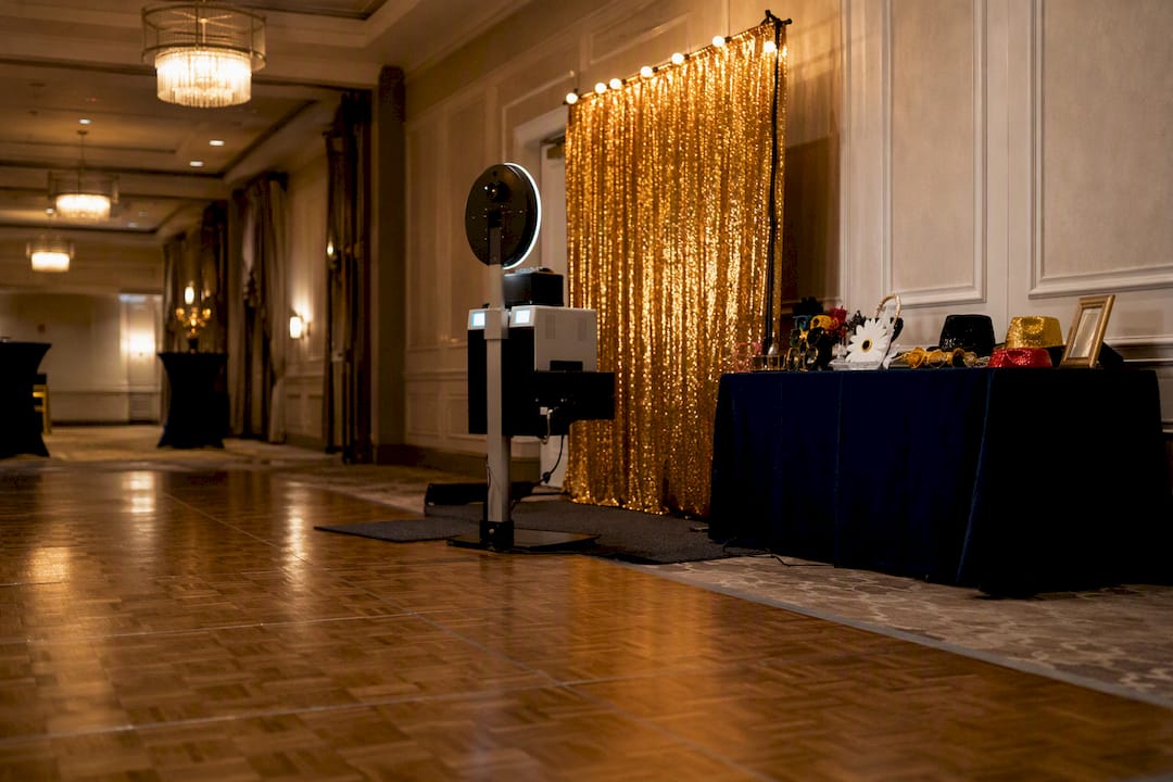 Photo booth setup in indoor ballroom near dance floor