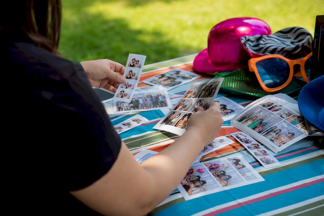 Hands arranging photo booth print layouts