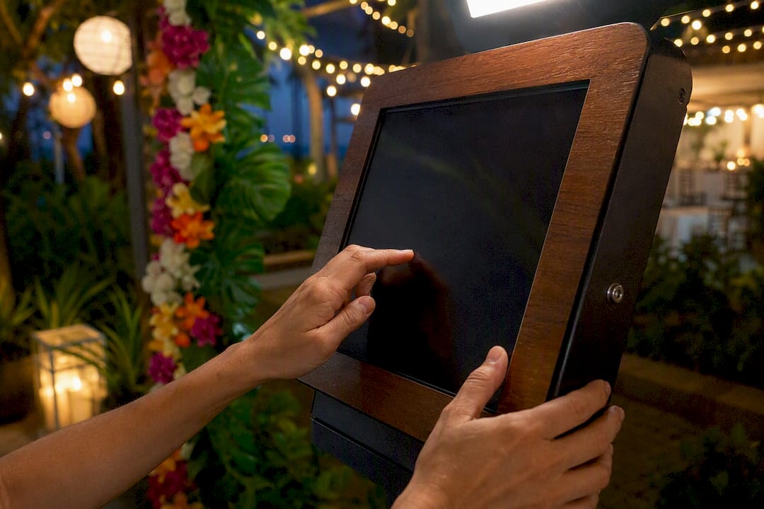 Guest hands tapping photo booth sharing kiosk