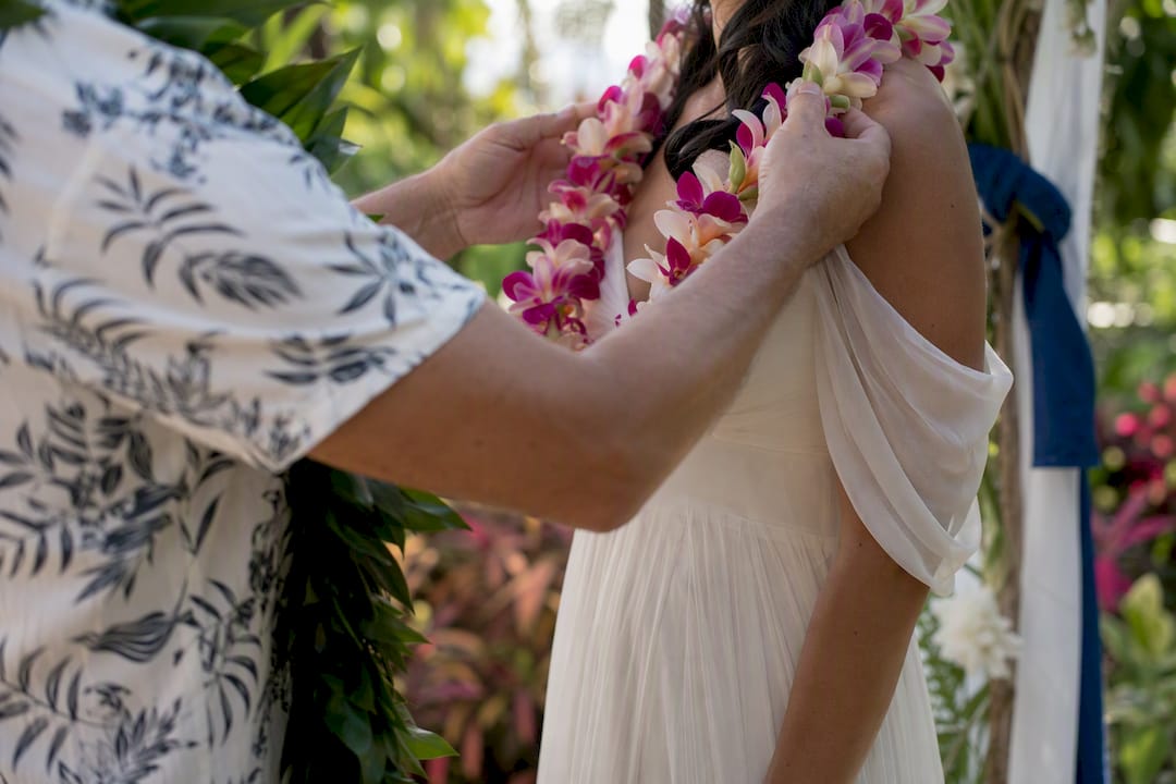 Hands exchanging lei at wedding ceremony