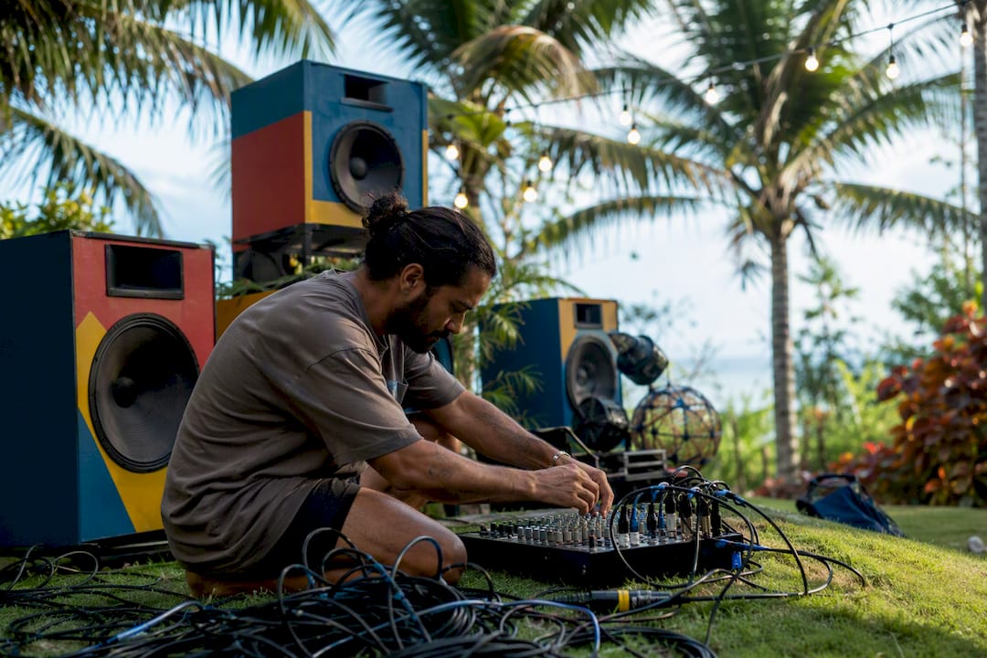 DJ adjusting audio mixer and connecting cables