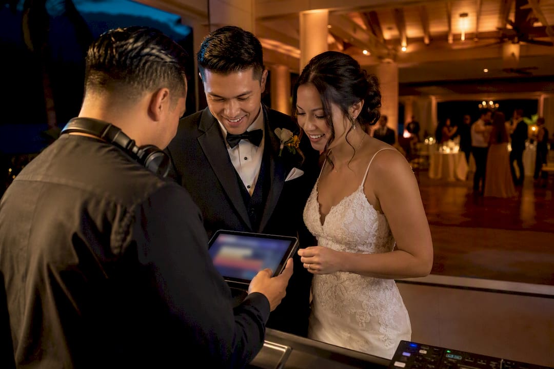 Couple reviewing wedding music restrictions with DJ