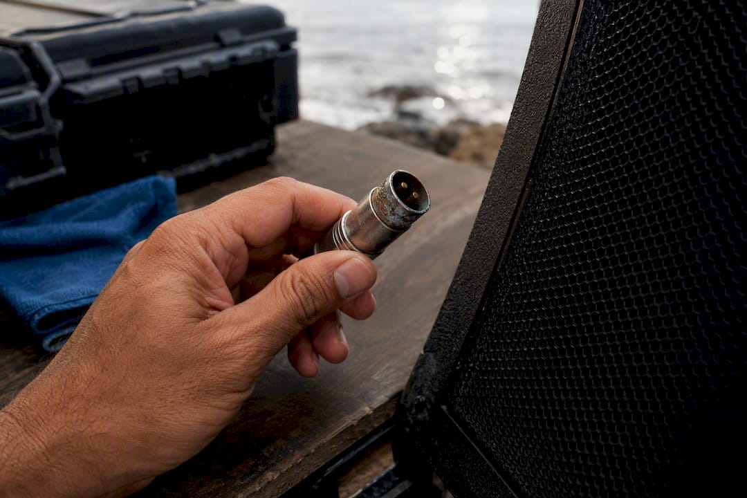 Technician inspecting salt-exposed audio connector
