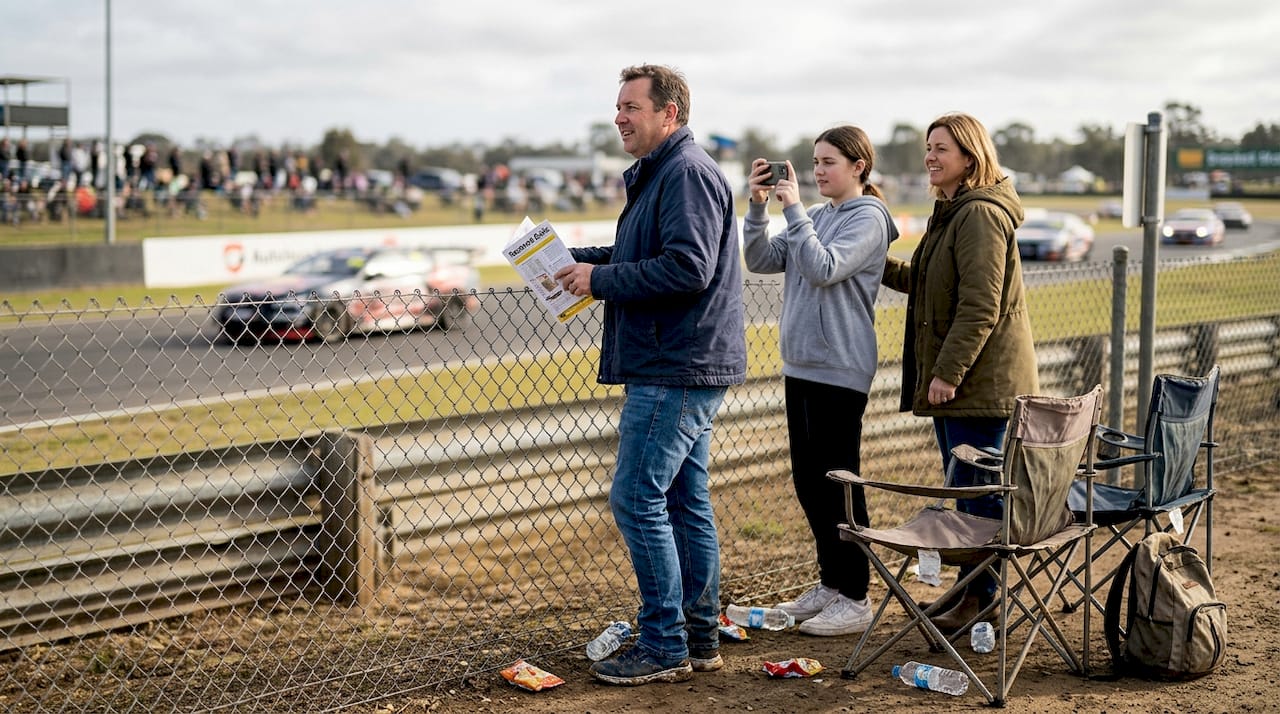Spectators watching from racetrack fence