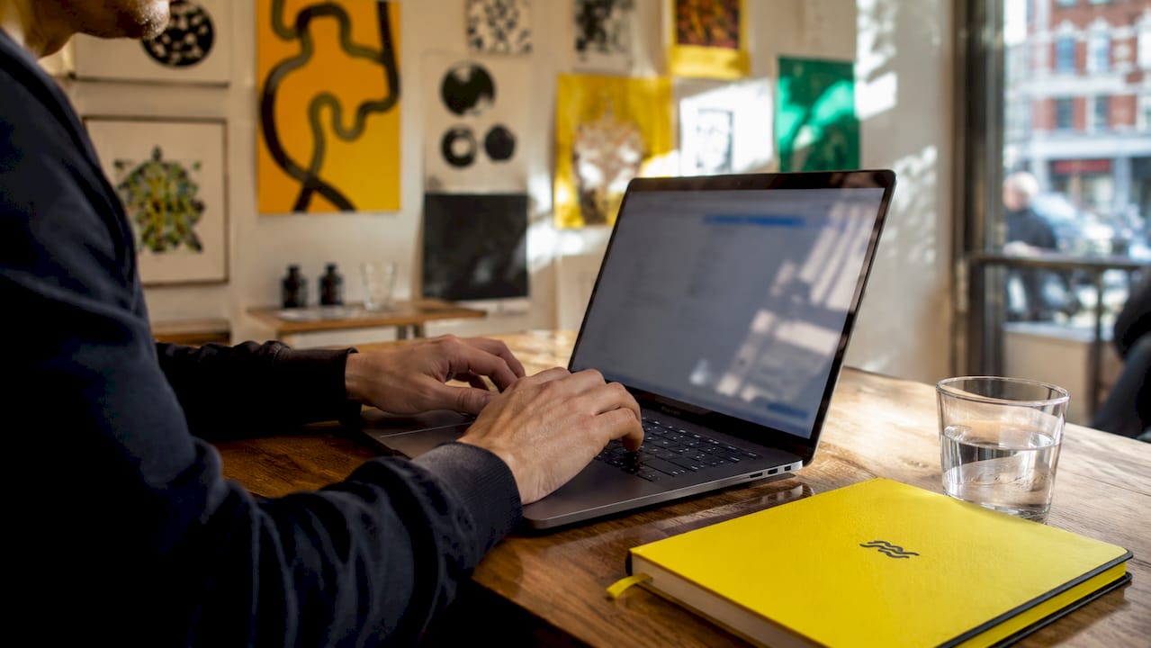 Hands typing Google Ads bidding strategy on laptop keyboard