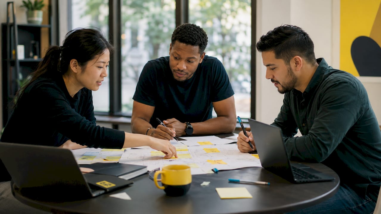 Diverse team mapping keywords at meeting table