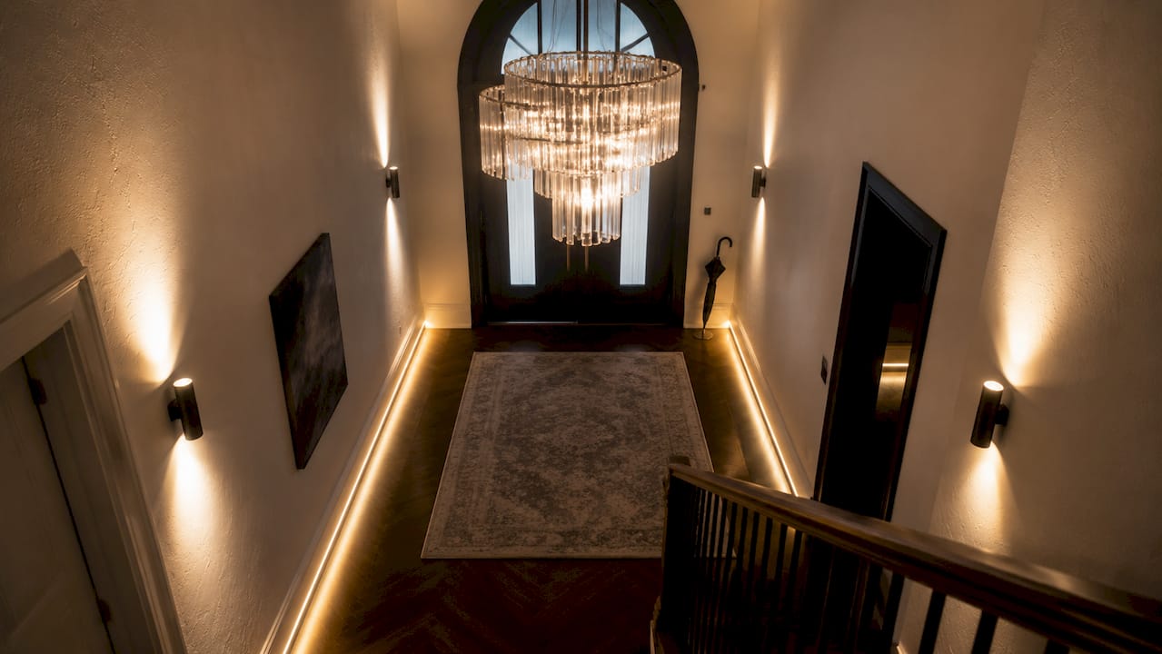 Dramatic uplighting accentuates high entryway ceiling