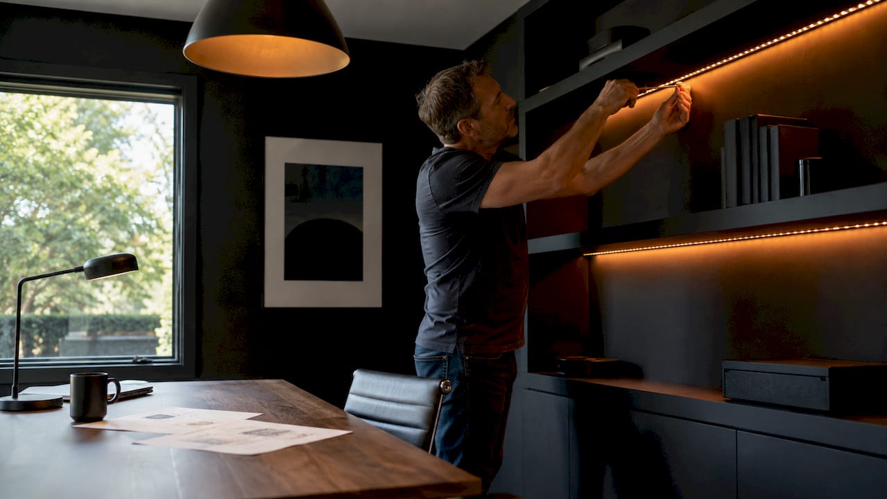 Man installing RGBW LED strips in kitchen