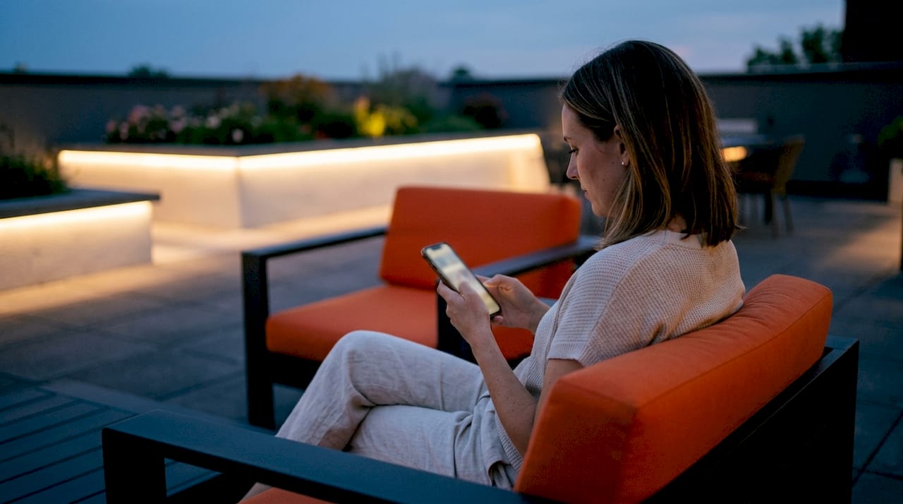 Hands adjusting outdoor lighting app on smartphone