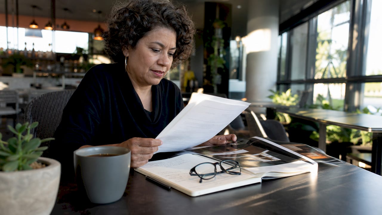 Woman reviewing lighting warranty documents at home office