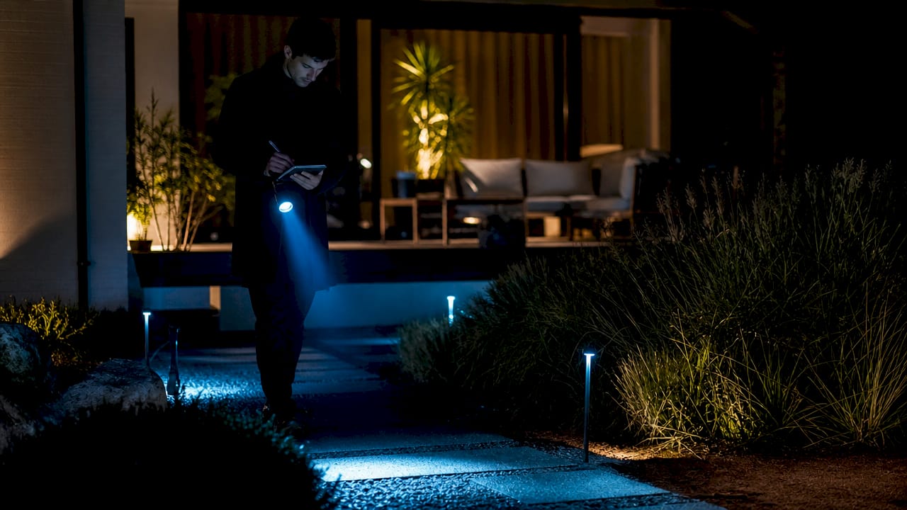 Man assessing outdoor lighting at night