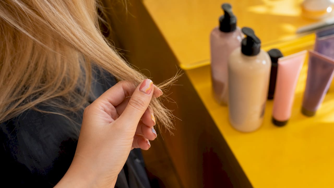 Close-up of damaged bleached hair strand in glove