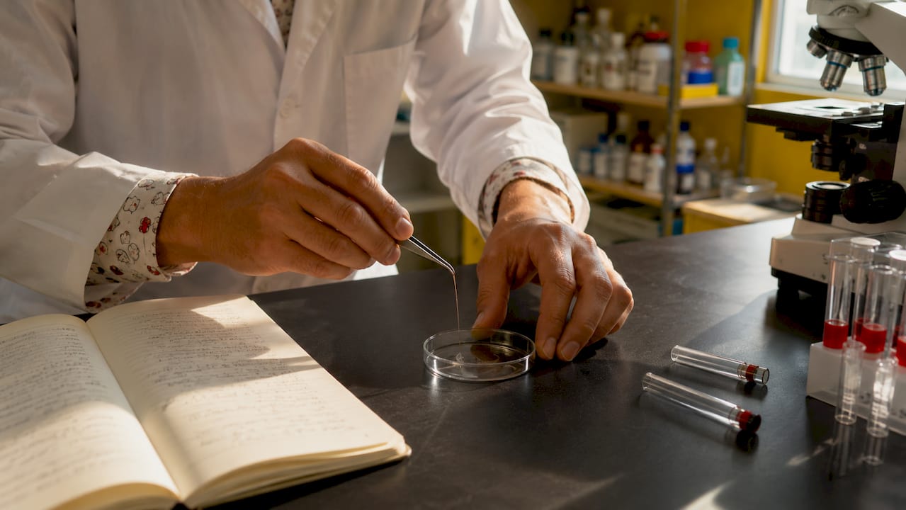Lab technician handling 1cm hair segment with tweezers