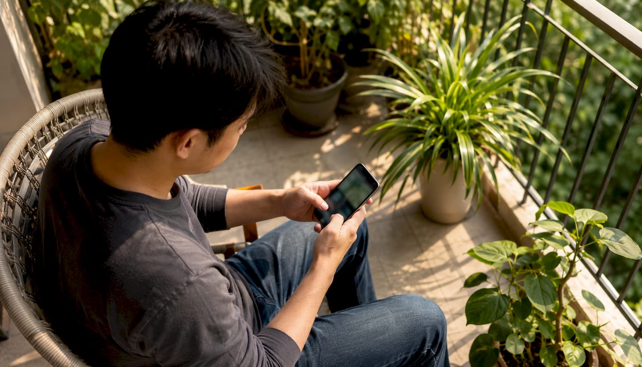 Young man using addiction recovery app at home