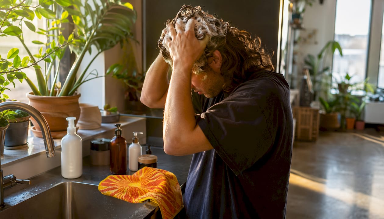 Person shampooing hair with clarifying shampoo at sink