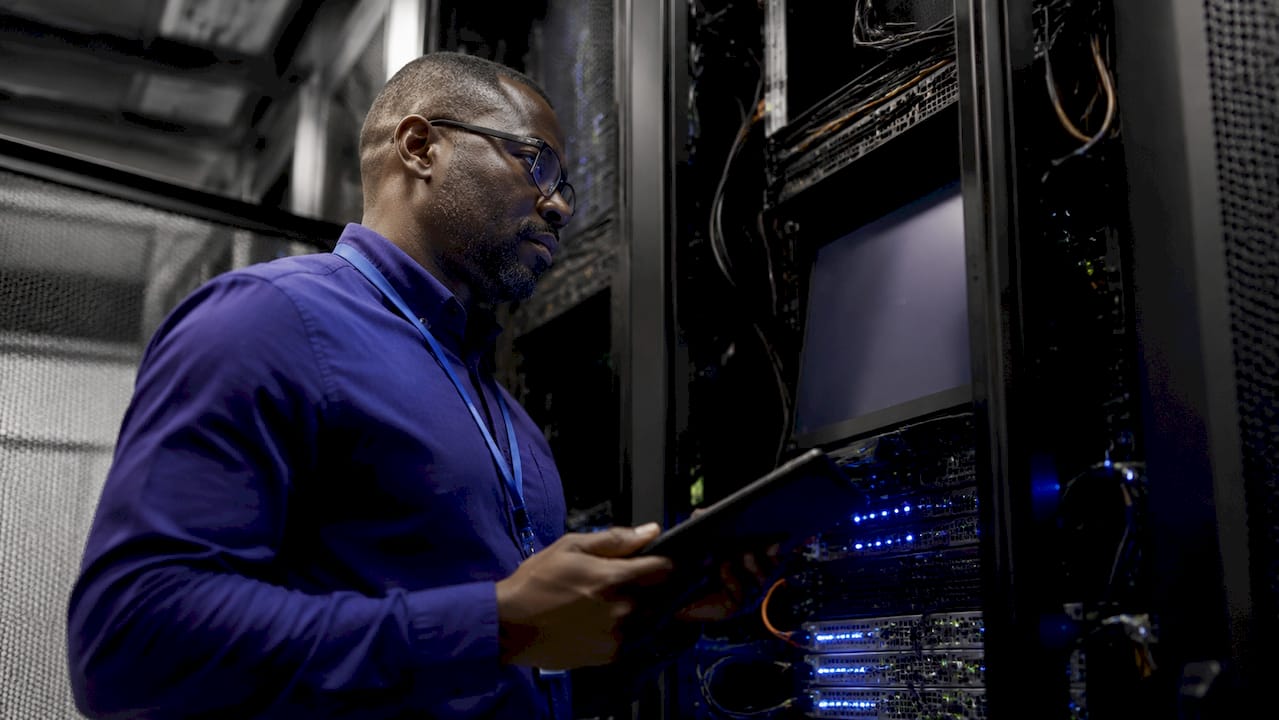 IT technician inspecting server monitoring equipment