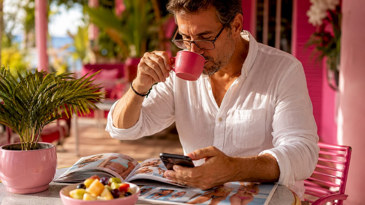 Man planning swimwear purchase with catalogs