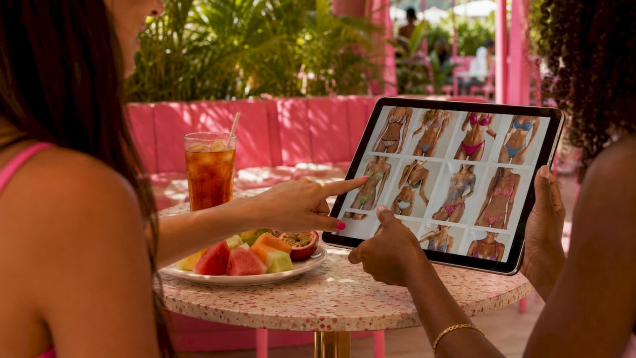 Hands browsing swimwear clearance online on laptop