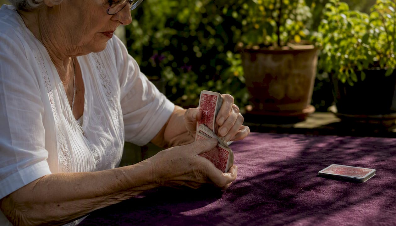 Hands shuffling cards in warm room