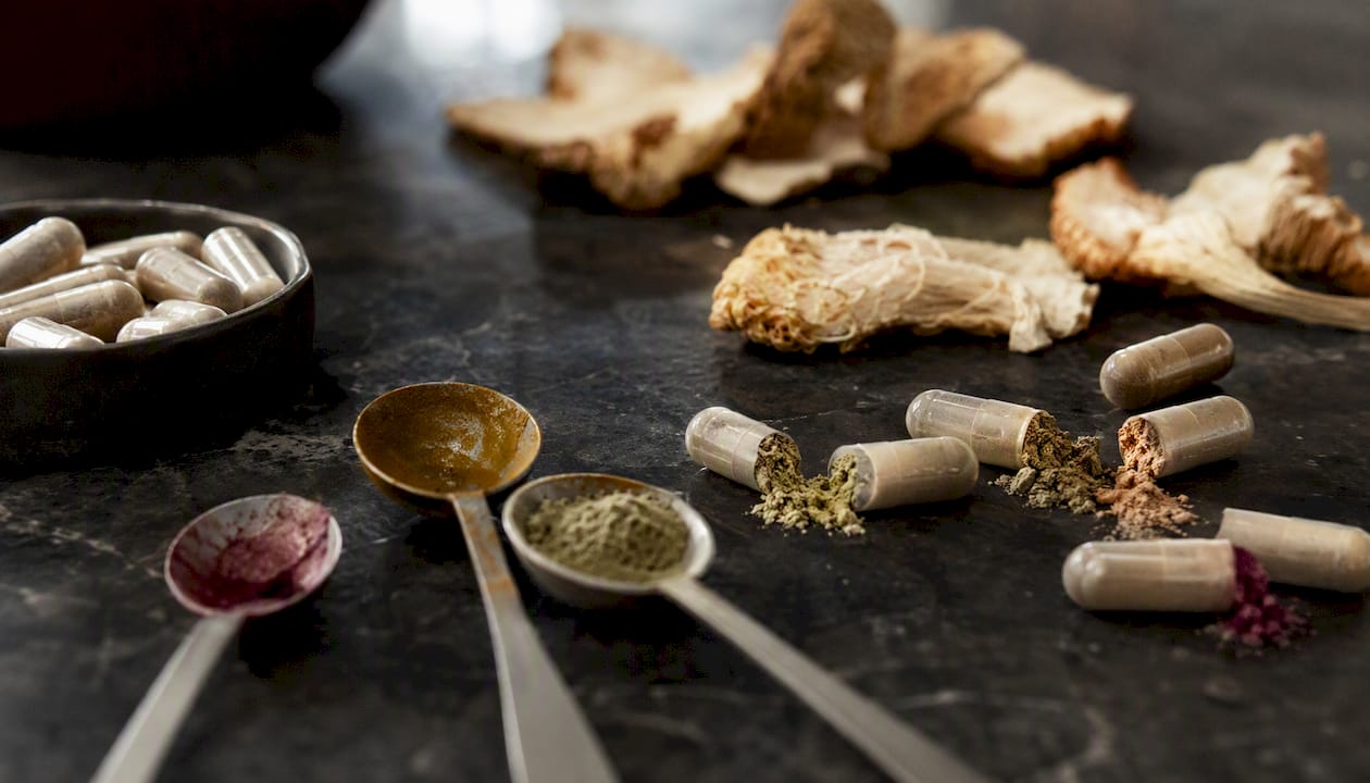 Supplement capsules, powders, and mushroom slices close-up