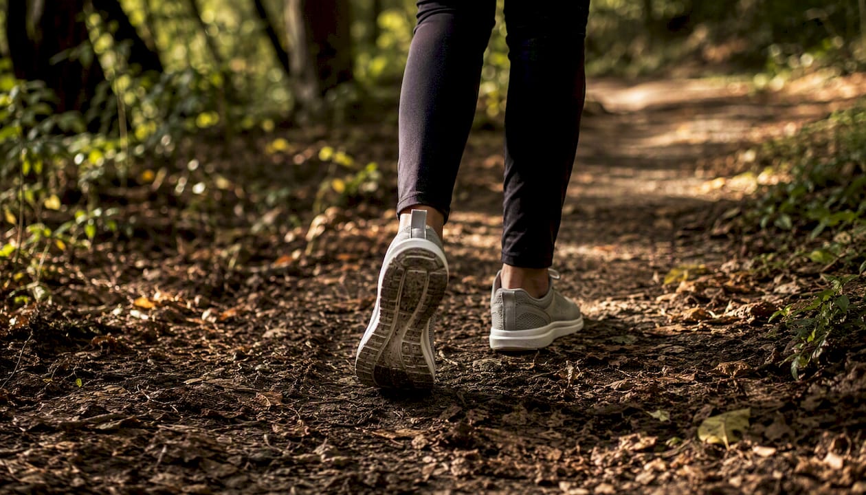 Legs walking briskly on park path