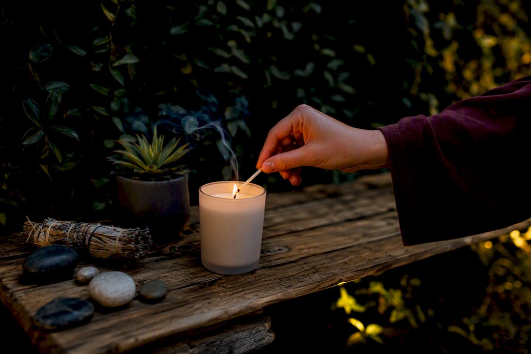 Hand lighting candle for stress relief ritual