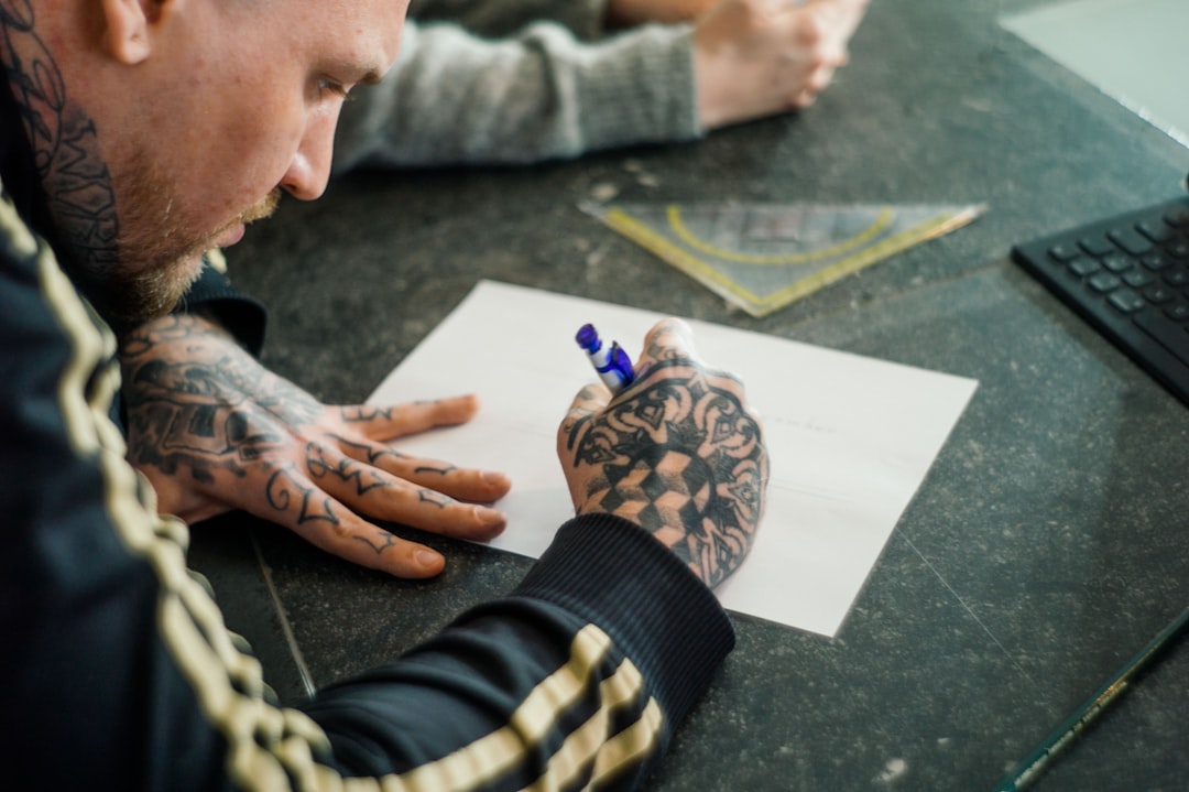 Tattoo artist sketching flash design in sunlit studio