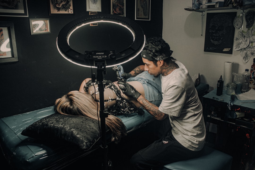 Tattoo artist sketching design with client