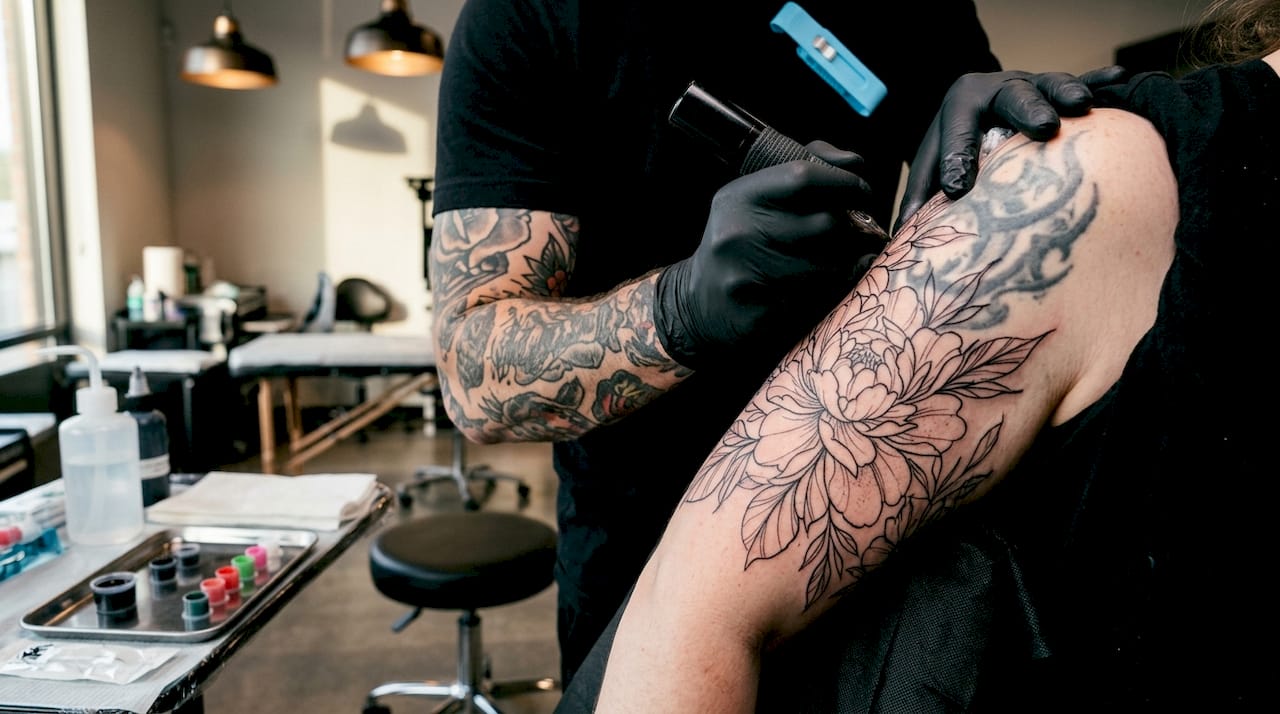 Tattoo artist detailing cover-up tattoo on arm
