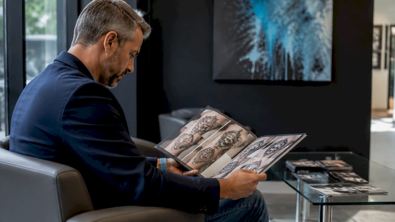 Client reviewing tattoo artist portfolio book