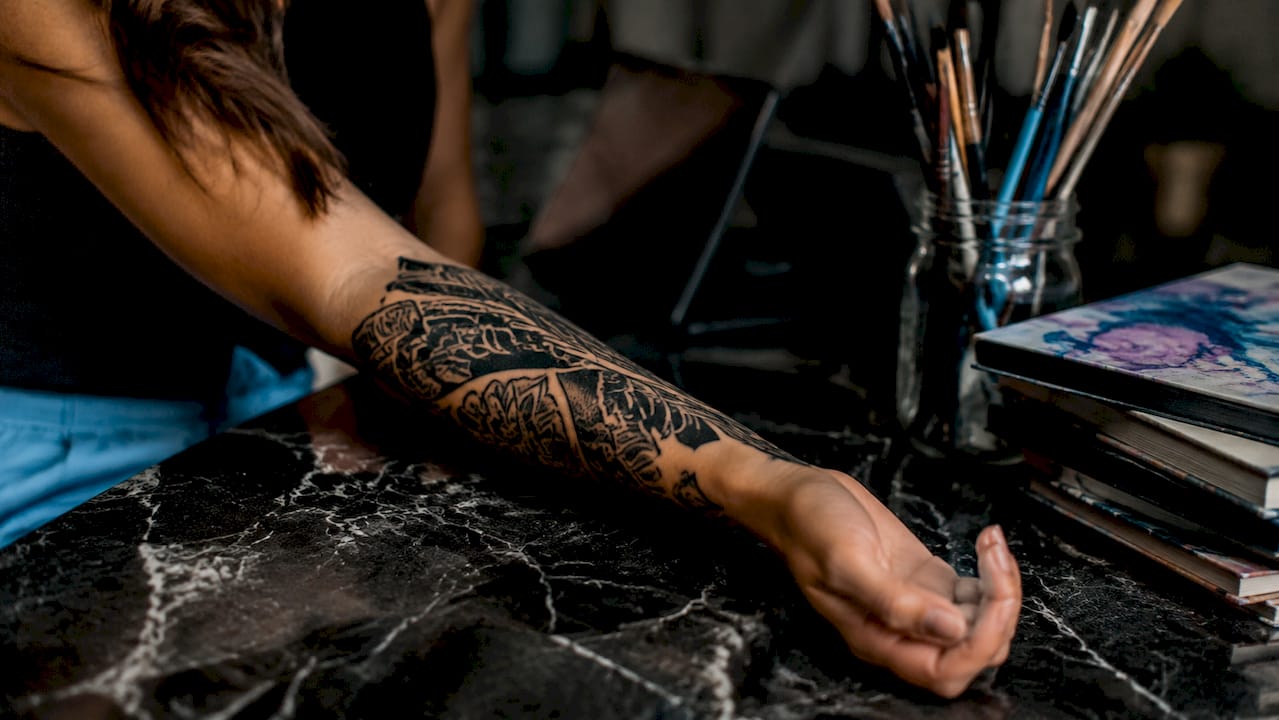 Close-up of forearm with blackwork tattoo patterns